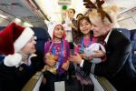 2 smiling little girls get hugs from 2 United flight attendants during a Fantasy Flight 