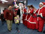 Little boy passenger greeted by a giant snowman and Mr. and Mrs. Claus