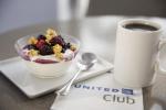 Image of bowl of yogurt with mixed berries and granola next to a cup of coffee