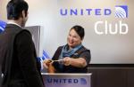 Image of smiling United employee assisting a customer at the United Club desk