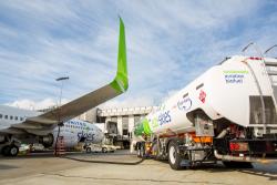 Airplane on tarmac being fueld by truck with biofuel