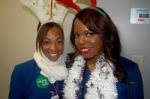 Two flight attendants wearing festive attire and reindeer antlers