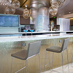 Image of chairs and drinks at the United Club bar with a television in the background