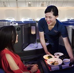 Flight attendant service food to customer on plane