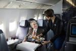 United flight attendant assisting a Business First passenger