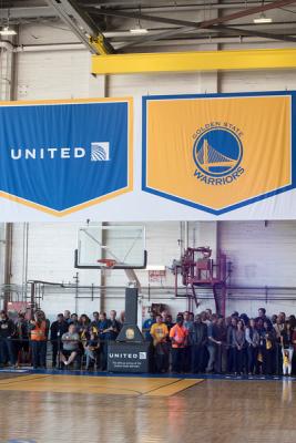 Basketball court with United employees and United and Golden State Warriors banners hanging